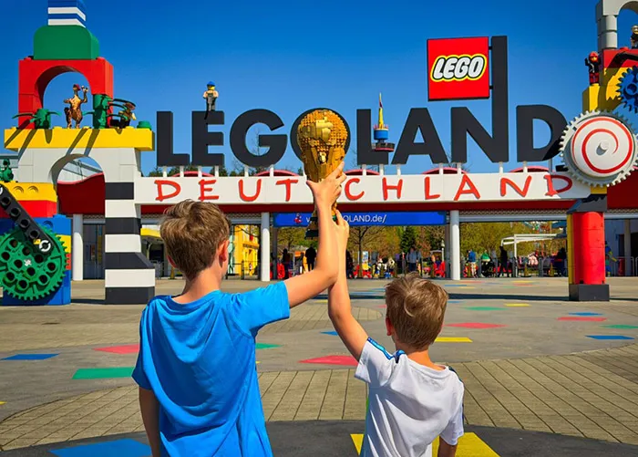 Kinder mit dem Fußball WM-Pokal vor dem LEGOLAND Deutschland